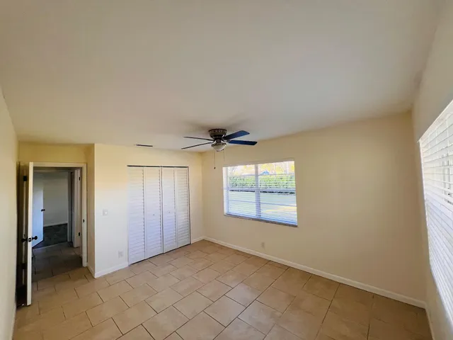 an empty room with windows and closet