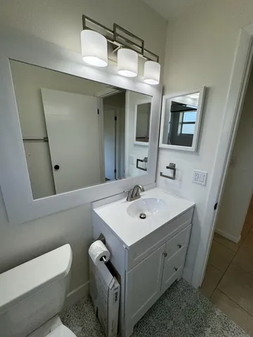 a bathroom with a toilet sink and mirror