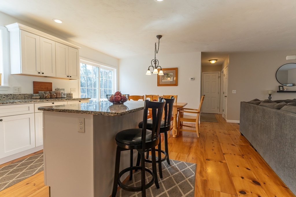 11 Shea Road West Brookfield, MA 01585 - Photo 23 of 42 a kitchen with stainless steel appliances granite countertop a stove a sink a dining table and chairs with wooden floor