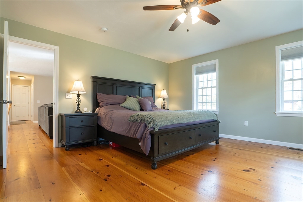 11 Shea Road West Brookfield, MA 01585 - Photo 28 of 42 a spacious bedroom with a bed and a chandelier
