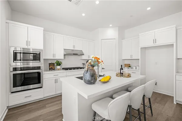 a kitchen with a sink a stove and chairs