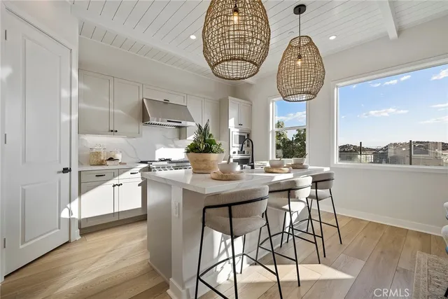 a kitchen with stainless steel appliances a table chairs and chandelier