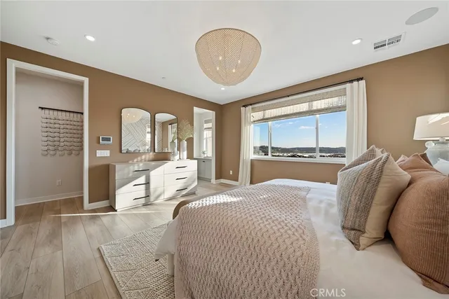 a bedroom with a large bed and a chandelier