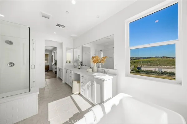 a spacious bathroom with a double vanity sink a mirror and a shower