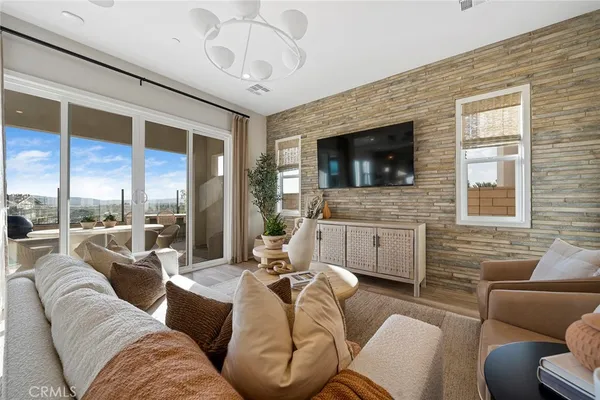 a living room with furniture a flat screen tv and a fireplace