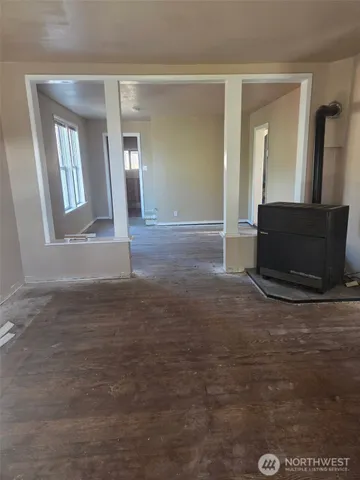 a view of a livingroom with wooden floor and a large window