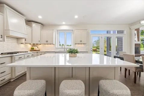 a kitchen with stainless steel appliances granite countertop a white cabinets and a couch