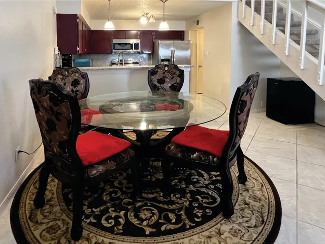 a kitchen with stainless steel appliances granite countertop a stove a refrigerator and a dining table