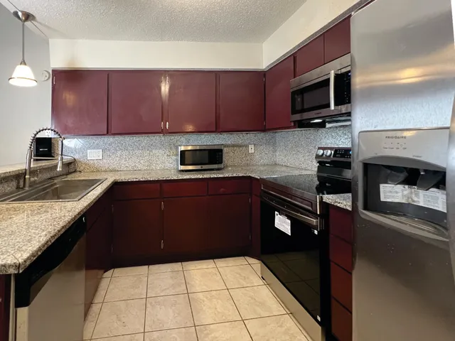 a kitchen with a sink a microwave and cabinets