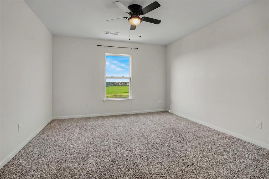 125 Sammy Venus, TX 76084 - Photo 26 of 39 Spacious interior room with neutral-toned walls, textured carpeting, and a ceiling fan with integrated lighting