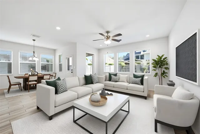 a living room with furniture kitchen view and a large window