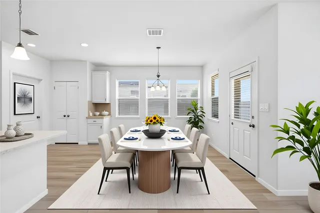 a dining room with furniture potted plants and wooden floor