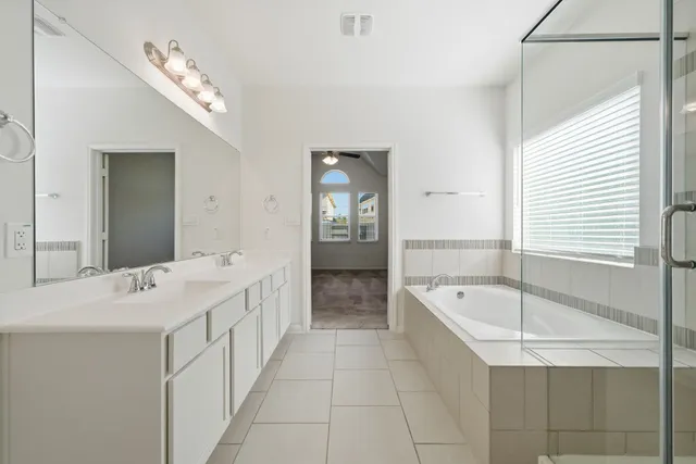 a bathroom with a tub sink and mirror