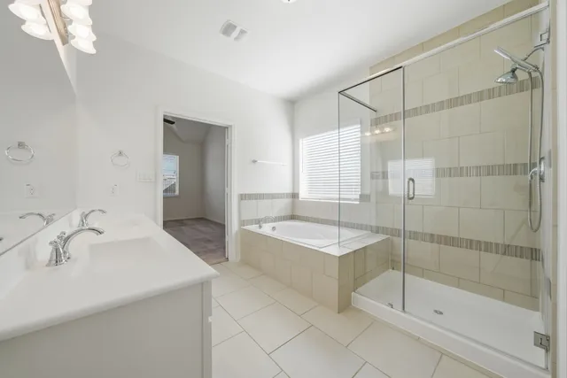 a spacious bathroom with a shower sink and mirror