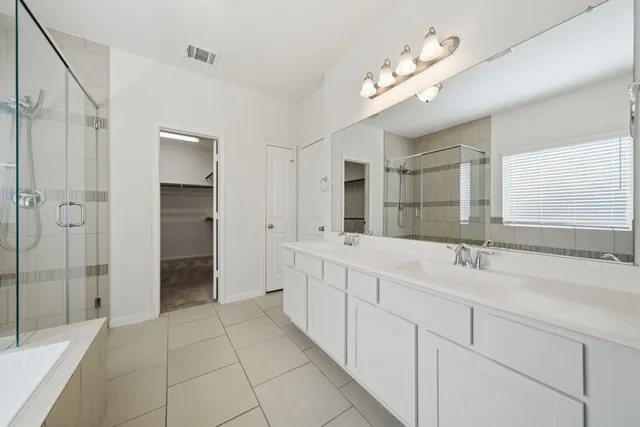 a spacious bathroom with a double vanity sink mirror and shower