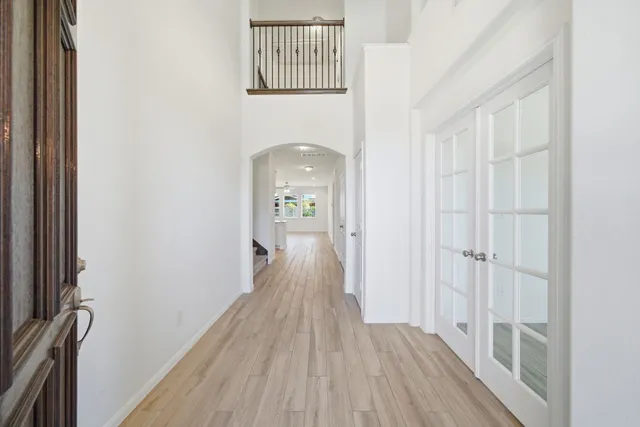a view of a hallway with wooden floor and staircase