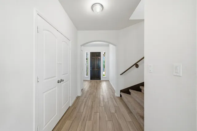 a view of a hallway with wooden floor and staircase