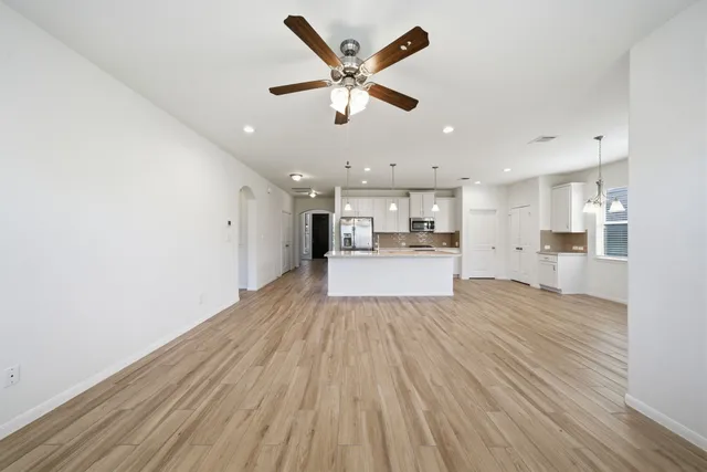 a view of a kitchen with wooden floor and a ceiling fan