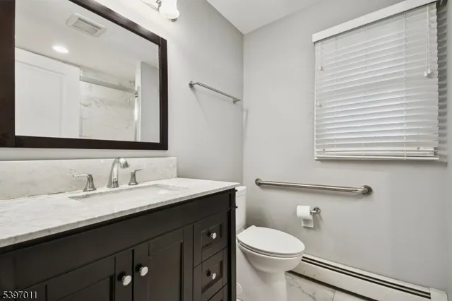 a bathroom with a toilet a sink and mirror