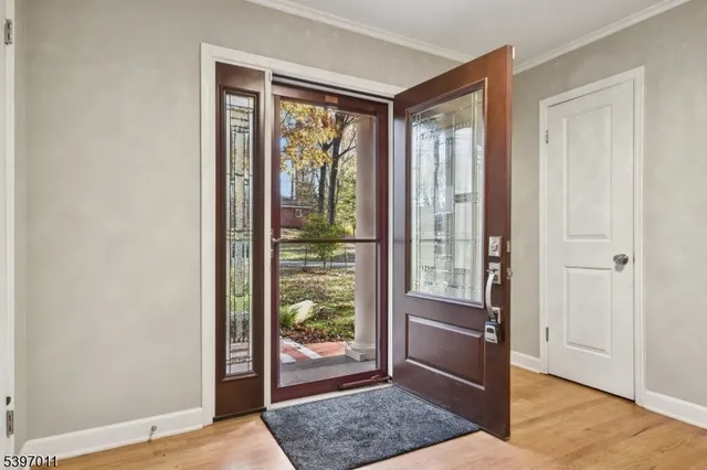 a view of a hallway with wooden floor and a bedroom