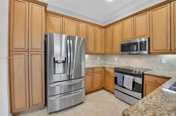 a kitchen with stainless steel appliances granite countertop a stove a sink and a microwave