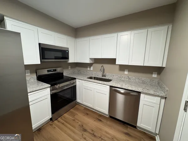 a kitchen with granite countertop a sink and steel appliances
