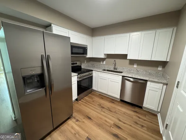 a kitchen with a refrigerator sink and stove top oven