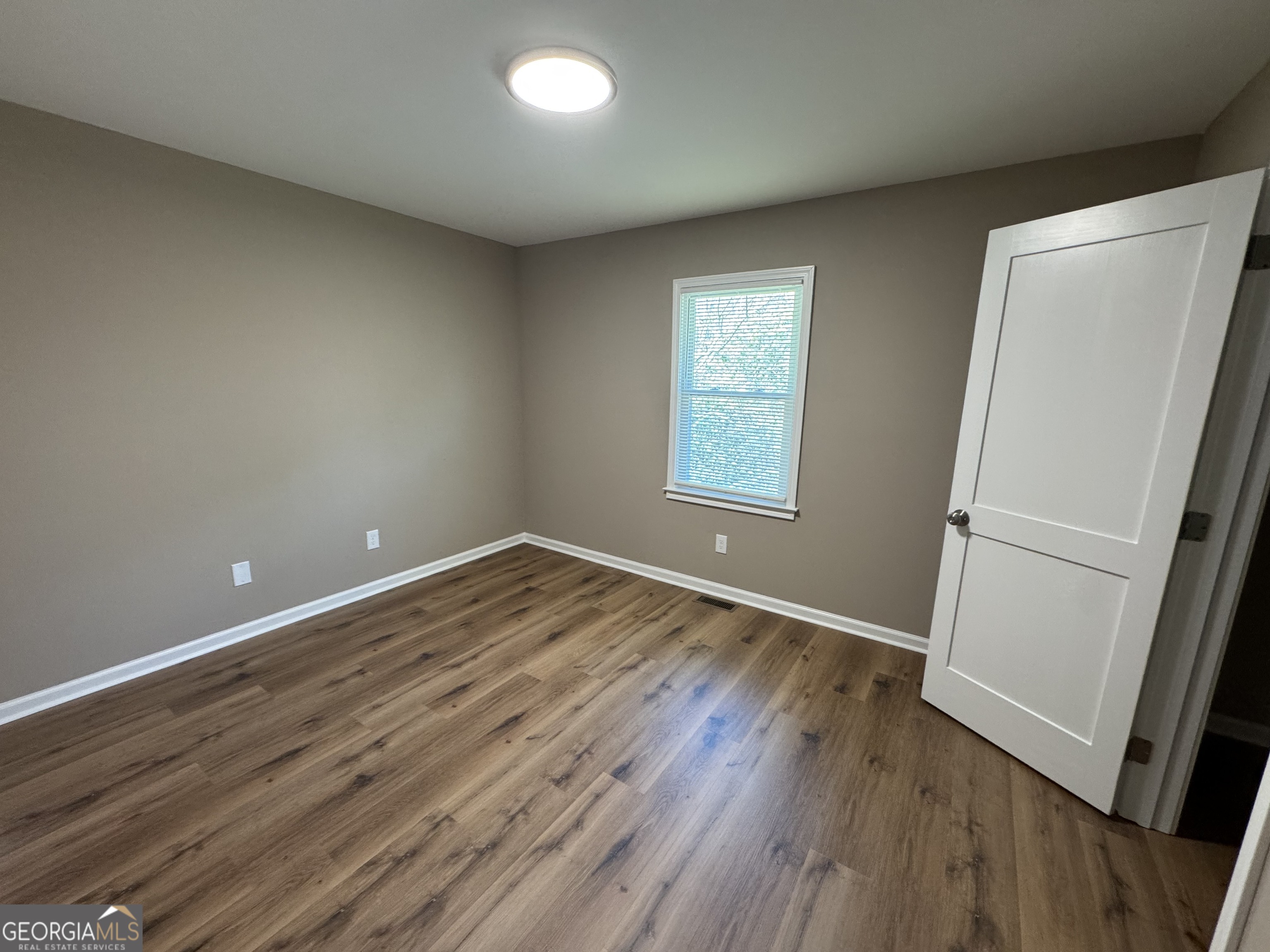 4235 Debby Street Columbus, GA 31907 - Photo 7 of 9 an empty room with wooden floor and window