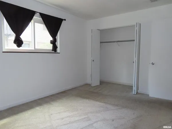 an empty room with a window and stairs