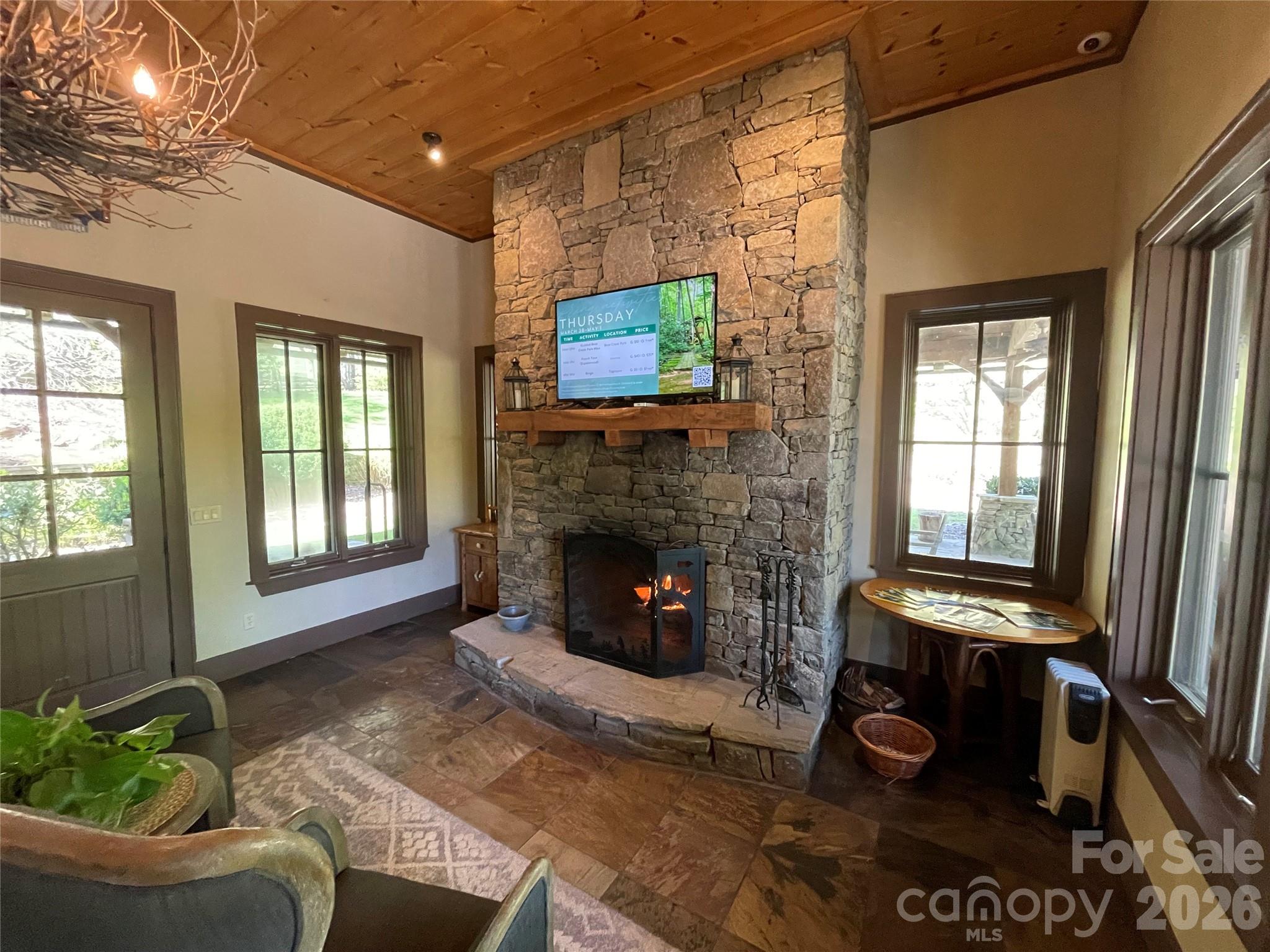 159 Songcatcher Court, Unit 159 Tuckasegee, NC 28783 - Photo 25 of 44 a living room with furniture a flat screen tv and a fireplace