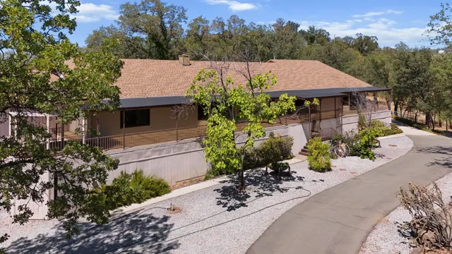 an aerial view of a house with yard and mountain view in back