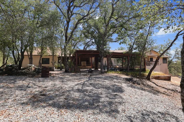 a view of a house with a yard and large tree