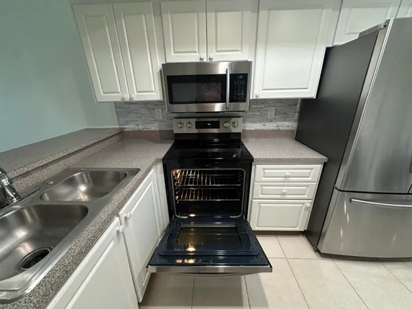 a kitchen with granite countertop a stove and a refrigerator