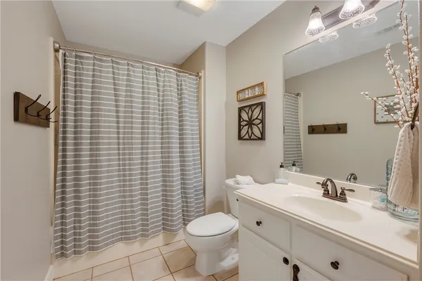 a bathroom with a granite countertop toilet sink and mirror