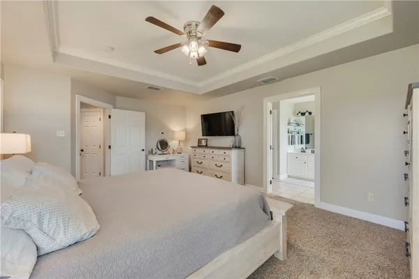 a spacious bedroom with a bed and a flat screen tv