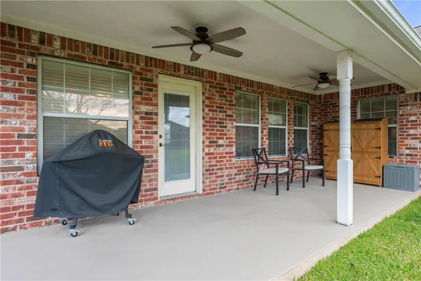 a view of a porch with chairs and a ceiling fan