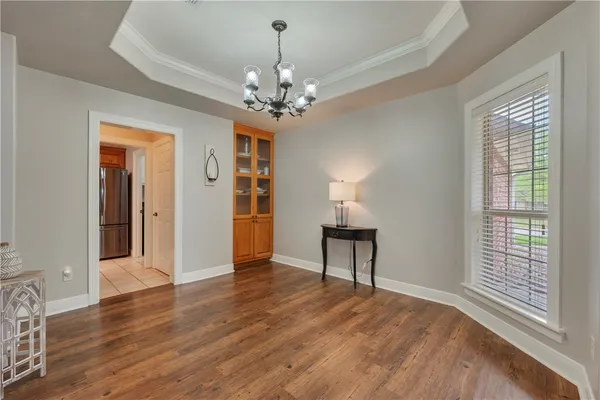 a view of an empty room with window and wooden floor