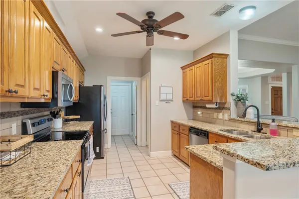 a kitchen with stainless steel appliances granite countertop a sink and a refrigerator