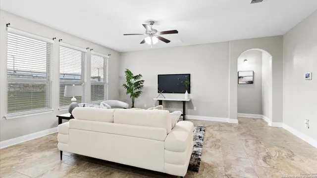 a living room with furniture a large window and a flat screen tv