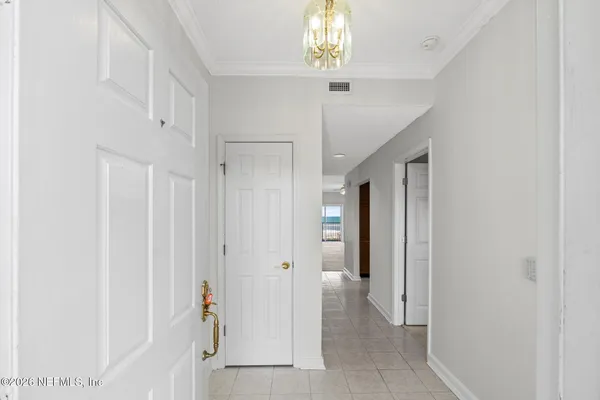 a view of an empty room with a chandelier fan and a fireplace