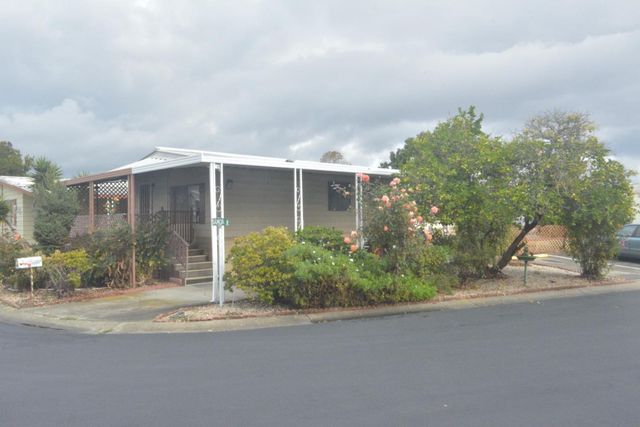a front view of a house with a yard and potted plants