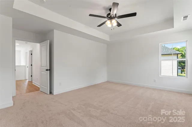 an empty room with a window and a ceiling fan