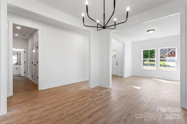 a kitchen with stainless steel appliances granite countertop a sink a stove and a wooden floors