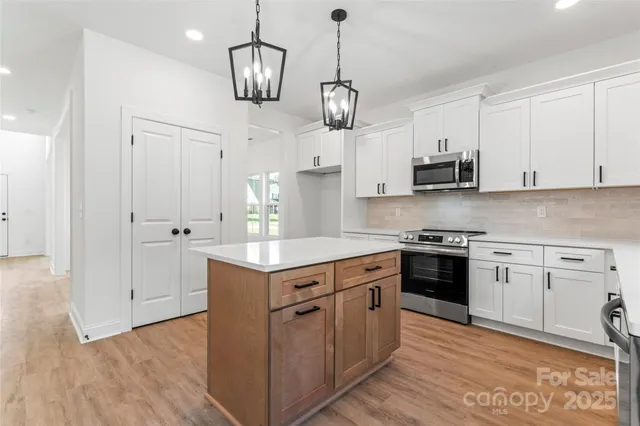 a view of a kitchen with a sink and a chandelier fan