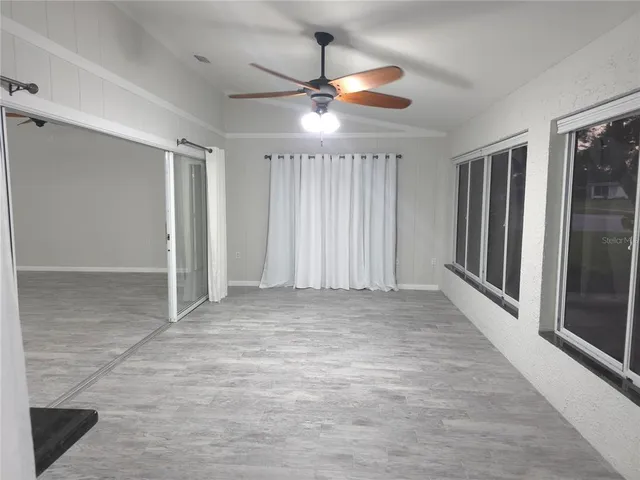 a view of a livingroom with a ceiling fan and window