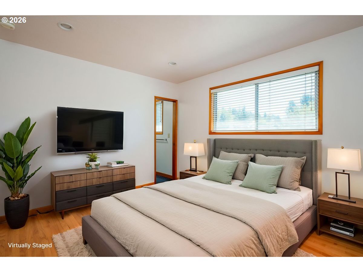 5815 Southwest Huddleson Street Portland, OR 97219 - Photo 12 of 35 a bedroom with a bed and a flat screen tv