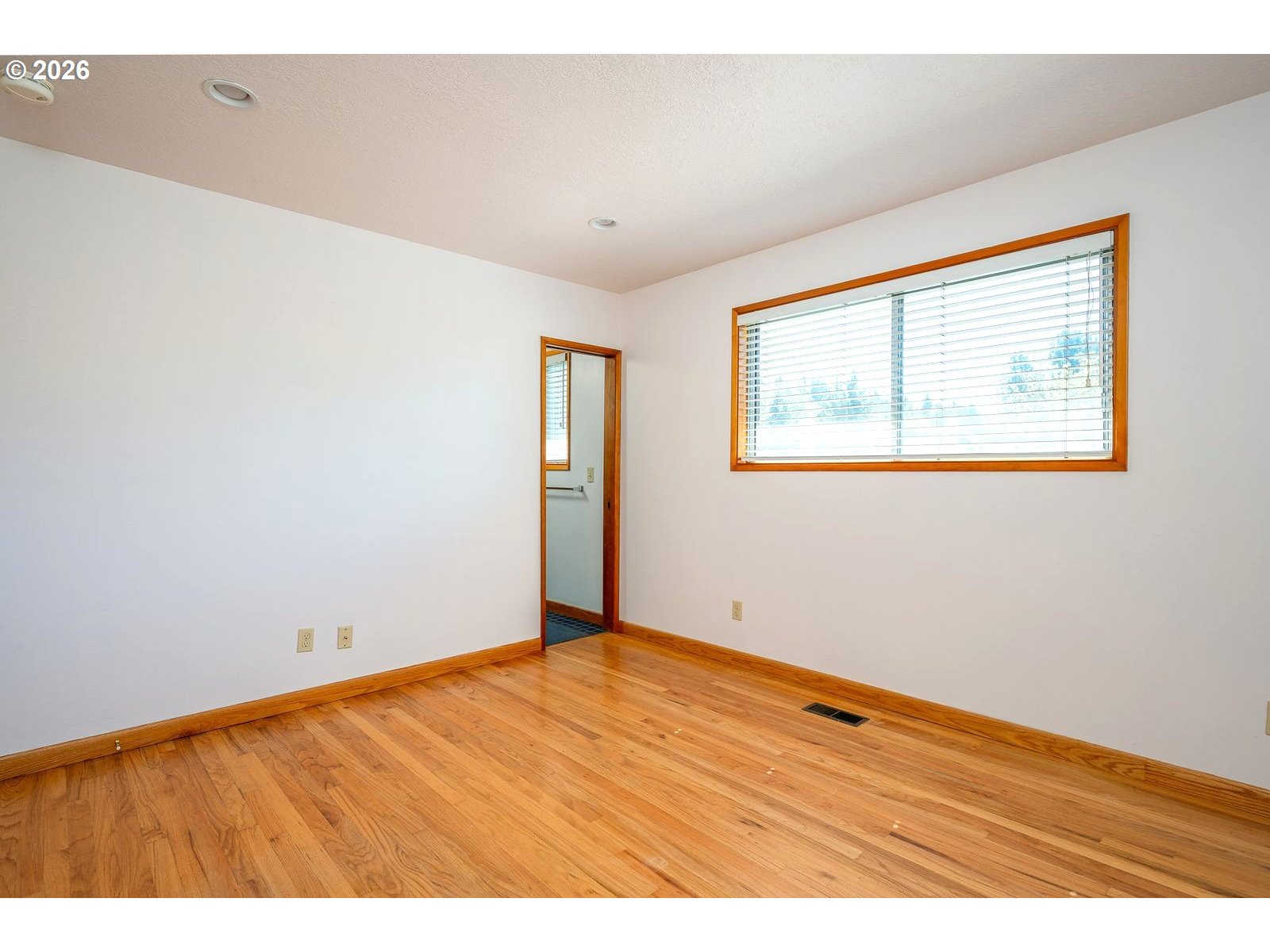 5815 Southwest Huddleson Street Portland, OR 97219 - Photo 13 of 35 a view of an empty room with wooden floor and a window