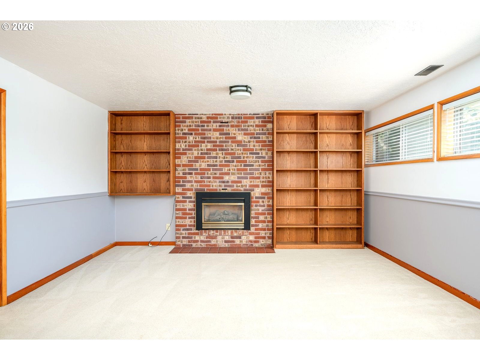5815 Southwest Huddleson Street Portland, OR 97219 - Photo 17 of 35 a view of an empty room with a fireplace and window