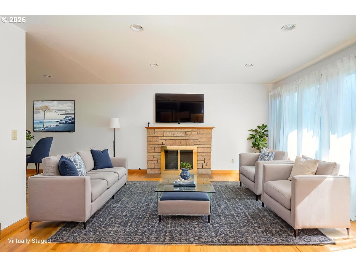 5815 Southwest Huddleson Street Portland, OR 97219 - Photo 4 of 35 a living room with furniture a fireplace and a flat screen tv