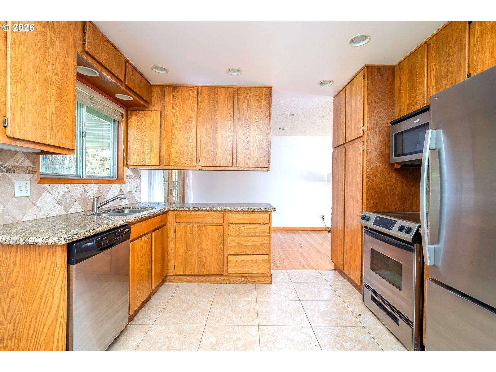 5815 Southwest Huddleson Street Portland, OR 97219 - Photo 8 of 35 a kitchen with granite countertop a stove a sink and a refrigerator